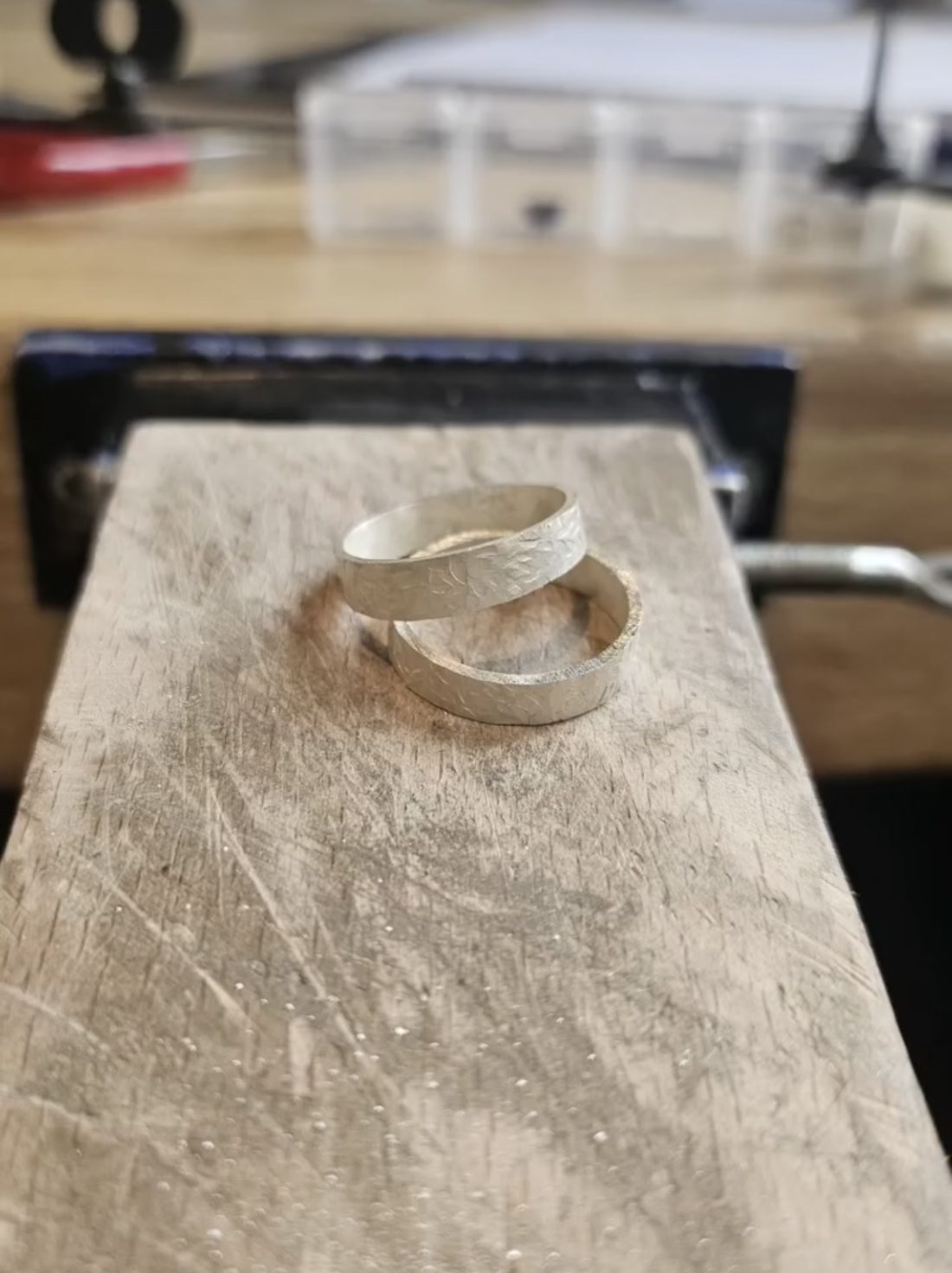 Twee gehamerde zilveren ringen op de werkbank